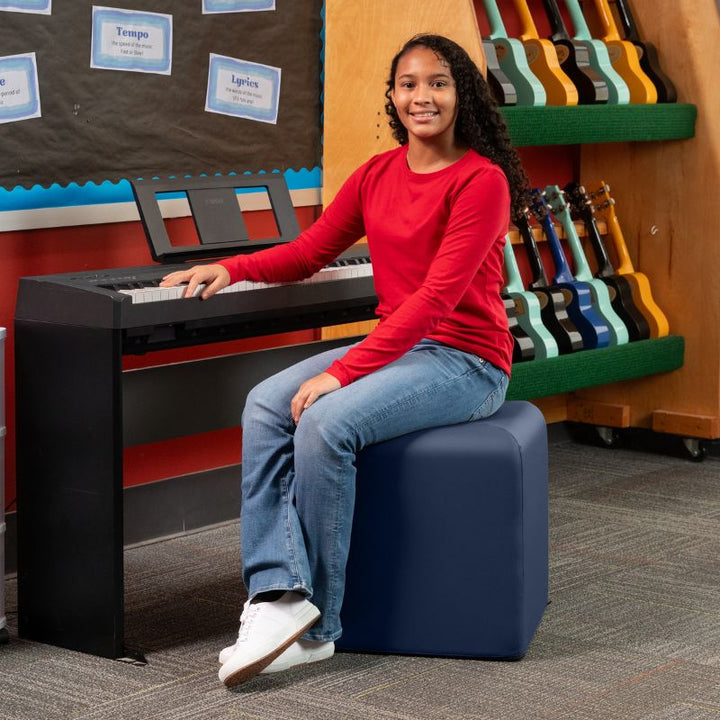 Jaxx Monroe 18in foam ottoman in navy blue vinyl, used as classroom seating in a music room