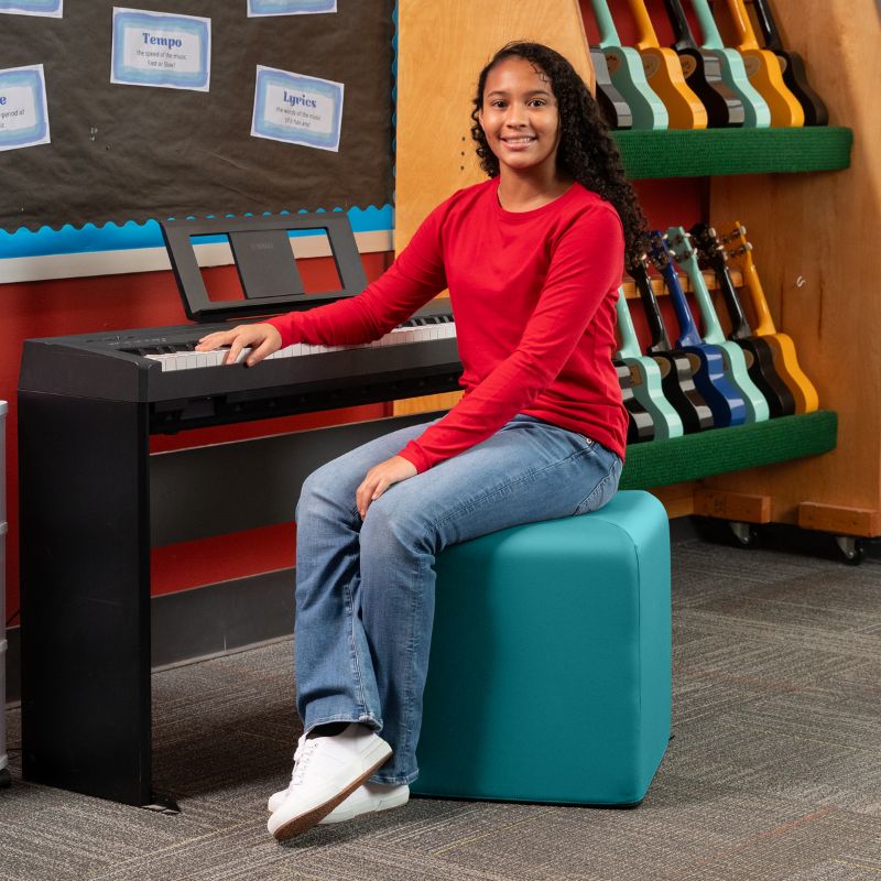Jaxx Monroe 18in foam ottoman in teal vinyl, used as classroom seating in a music room