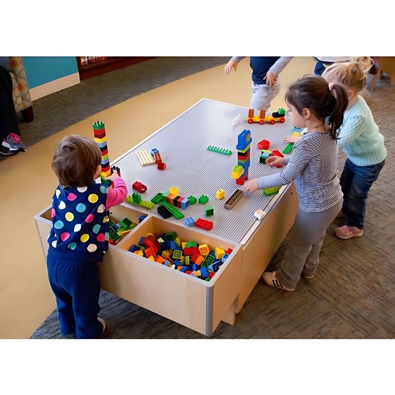 Child actively playing at the 3branch Double Discovery Table, showing the modular activity table layout from above