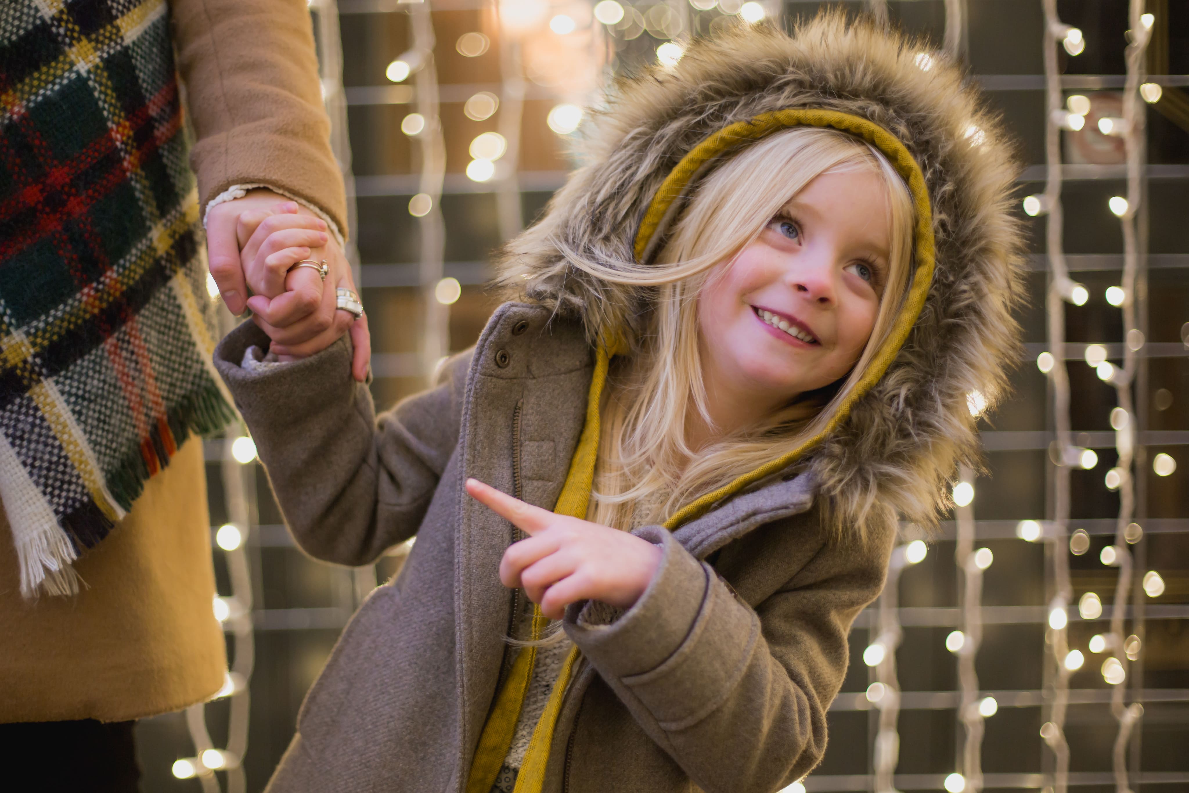 GIRL_HOLDING_PARENTS_HAND_STARING_AT_LIGHTS