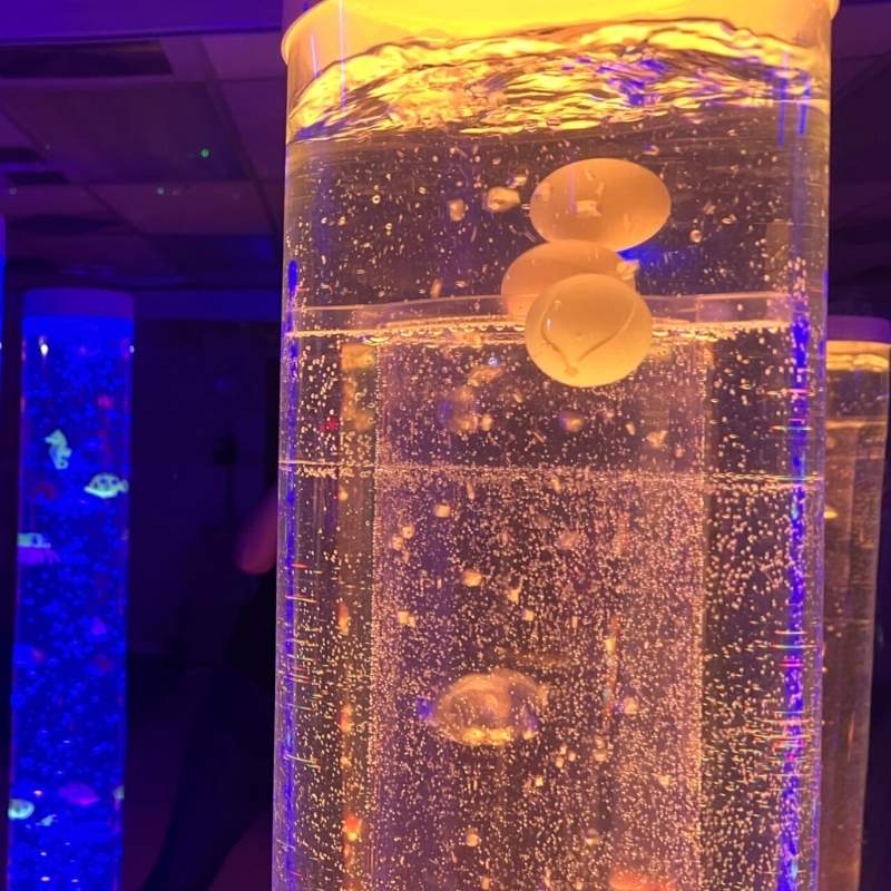 TFH 8" Bubble Tube Insert - Cascading Balls & Beads - close up view in yellowish tube with blue light tube in the background