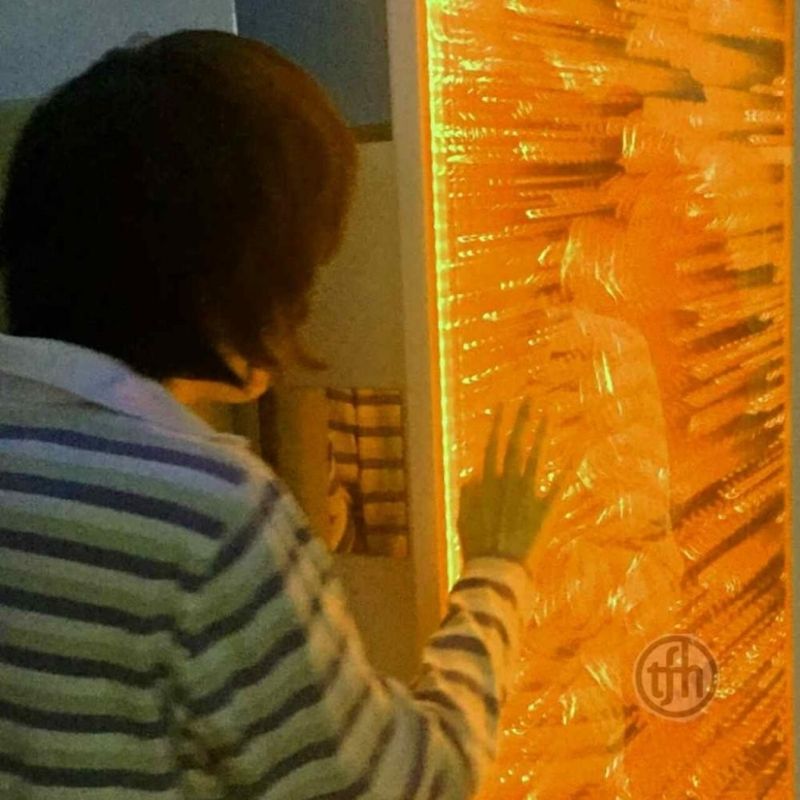 TFH Infinity Bubble Wall - Water & Lights - Adult active play touching the orange colored wall