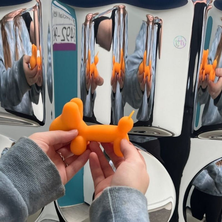 TFH Sensory Mirror With Padded Frame - Close up view with hand holding an orange balloon visible refelection