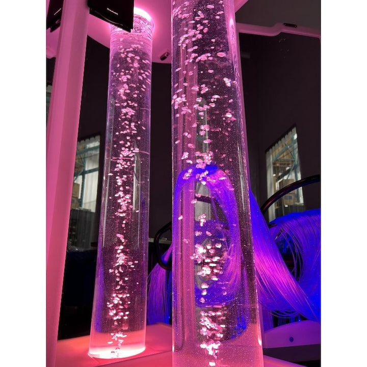 Close-up of the AHS Mirrored Bubble Rover illuminated in pink in a dark therapy room, showing the mirrored panel light multiplication effect
