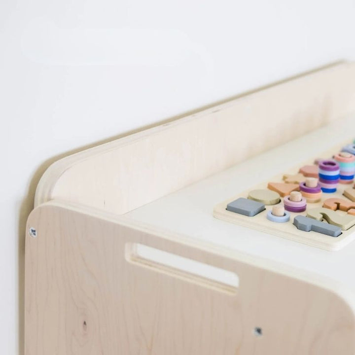 Banana Montessori Shelf with Borders top corner detail view showing the rounded edges, raised border height, and eco-friendly non-toxic wood finish of the Canadian-made Montessori shelf
