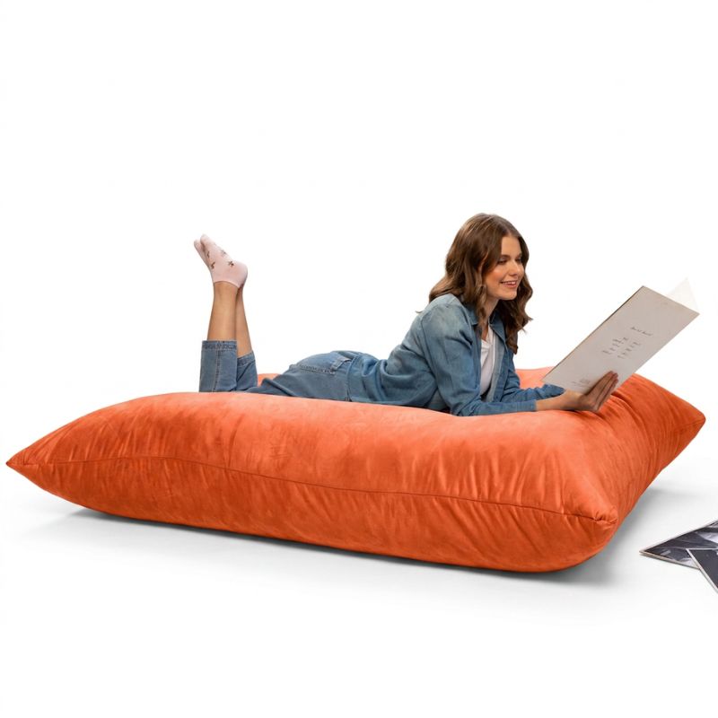 Reader relaxing on a Mandarin Jaxx Pillow Saxx 5 bean bag floor pillow, a giant crash pillow for rec rooms and sensory spaces