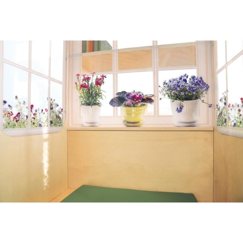 Inside view of the Whitney Brothers Nature View Window Seat, where potted flowers seen through bright window panels create a calm corner above the green cushioned seat