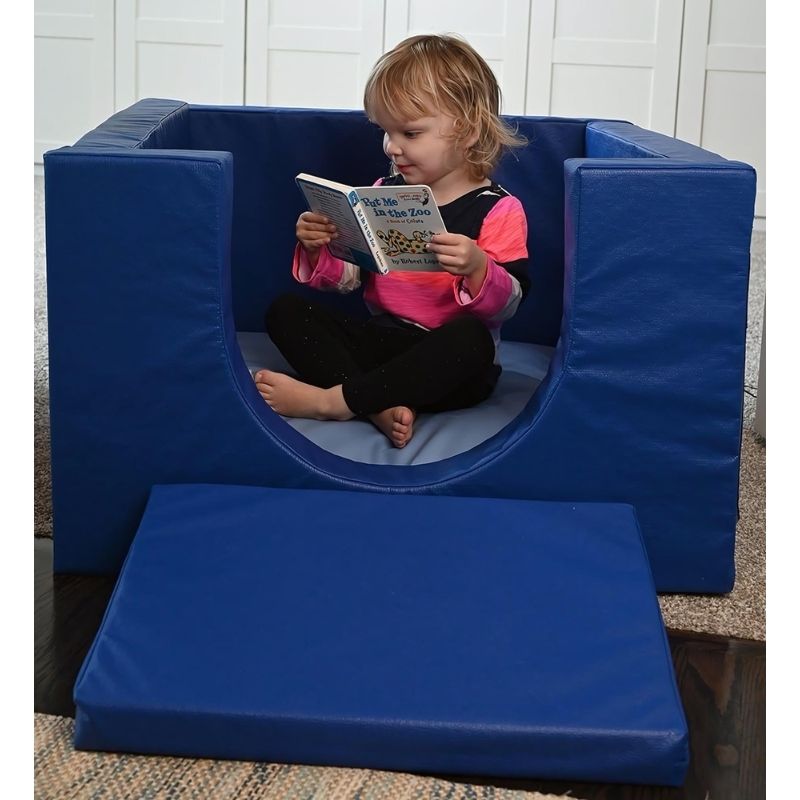 Child reading inside the Children's Factory Cozy Cube, showing the cushioned interior and enclosed soft foam walls of this infant and toddler quiet corner play space