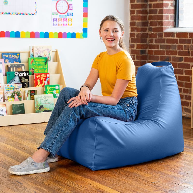 Student sitting on the Jaxx Pezzi classroom bean bag chair in royal blue vinyl in a colourful reading nook