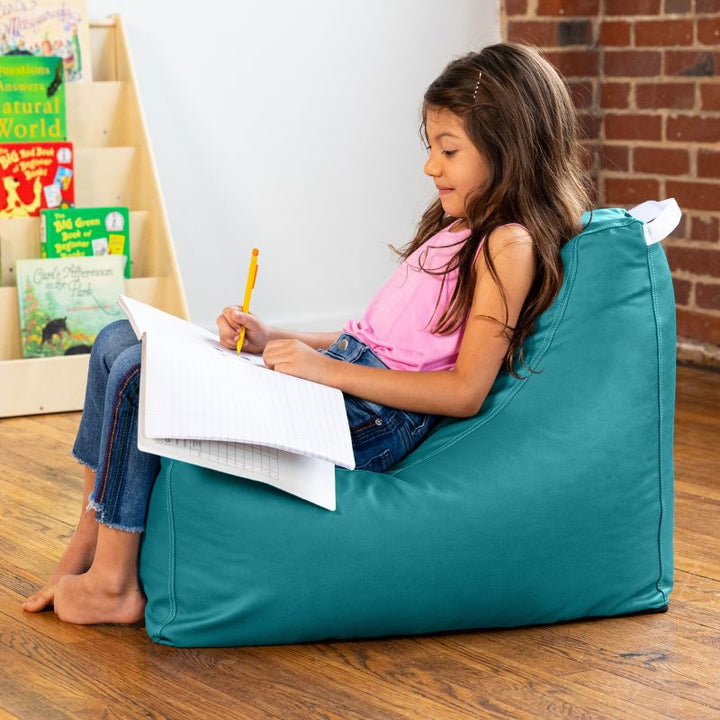 Child doing schoolwork on the Jaxx Pezzi classroom bean bag chair in turquoise vinyl, sensory seating for reading nooks