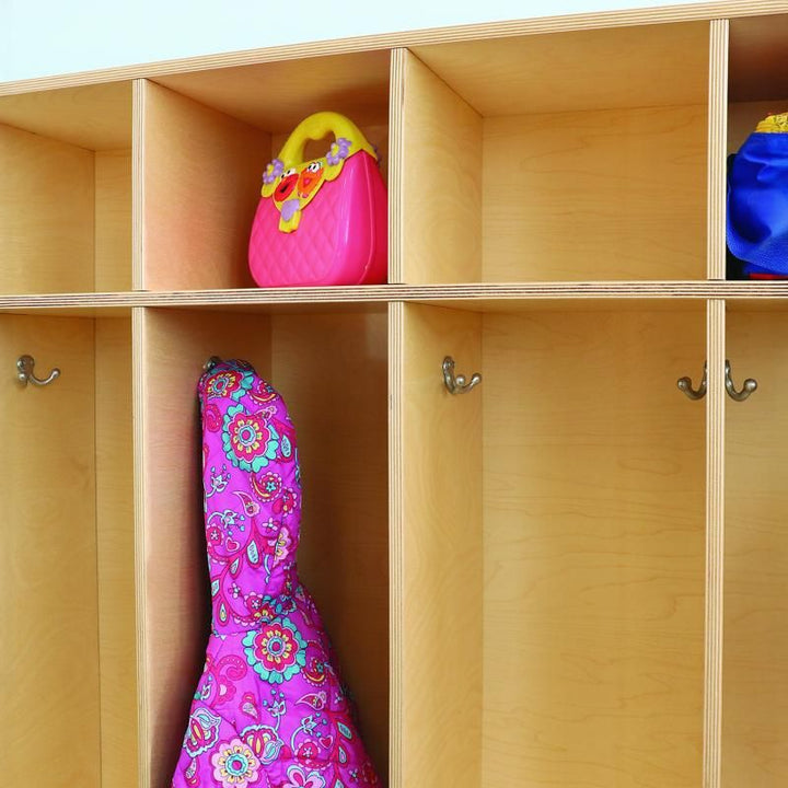 Close-up of Whitney Brothers coat locker double hooks with a child's jacket hanging and a purse in the coat cubbies above