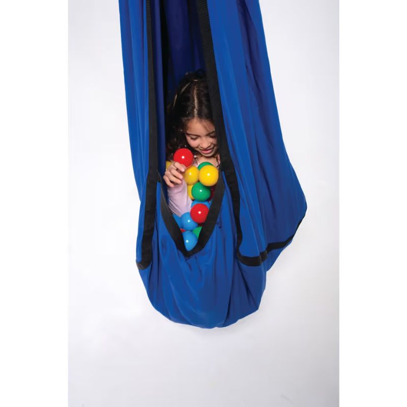 Child inside a TFH Cocoon Swing pod playing with coloured balls, a sensory hug swing for deep pressure and proprioceptive play
