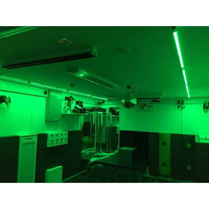 TFH Genie Colour Wash Kit illuminating a padded multi-sensory room in green light alongside bubble tubes and wall panels