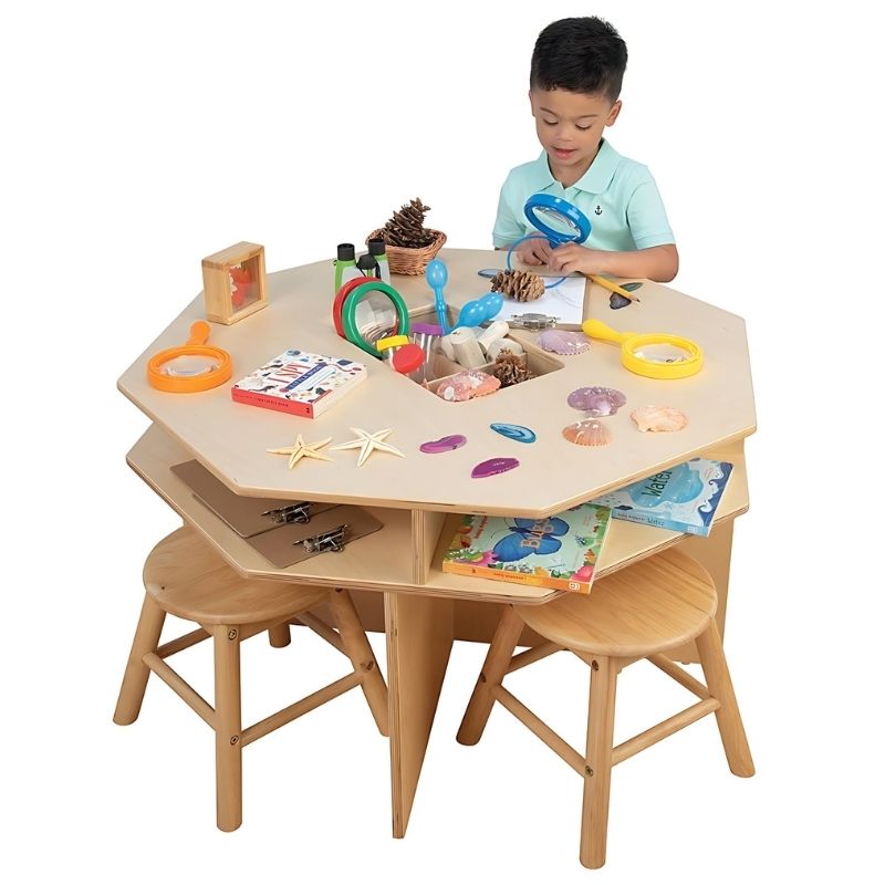 Child actively exploring at the Constructive Playthings Discovery Table, showing the hands-on STEM science centre table with divided tray in a classroom setting