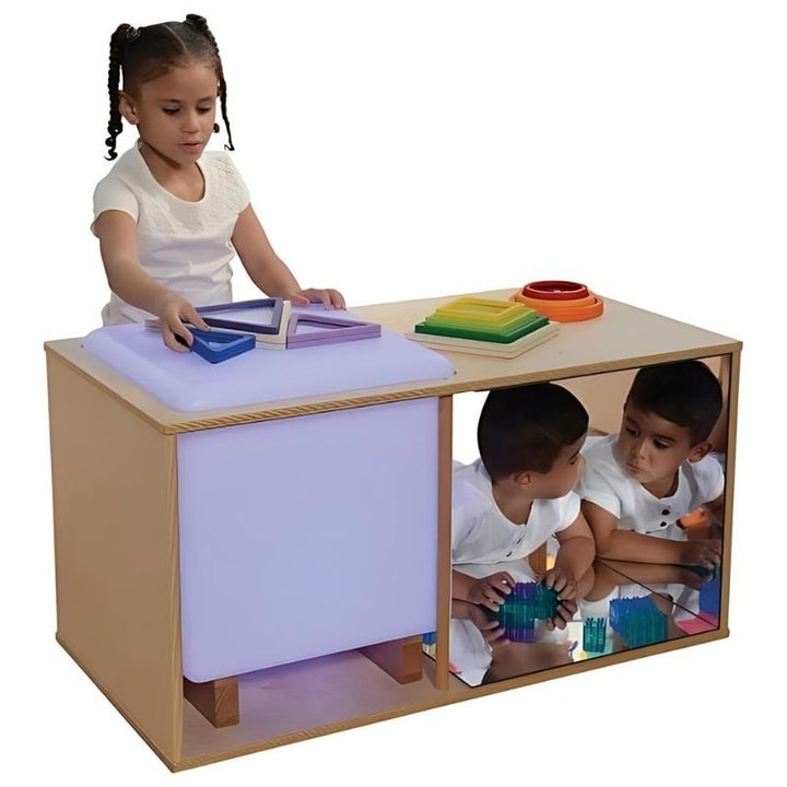 Child exploring the mirrored play space side of the Constructive Playthings Ultimate Light Studio, showing the shatterproof acrylic mirror reflection feature for visual and sensory learning