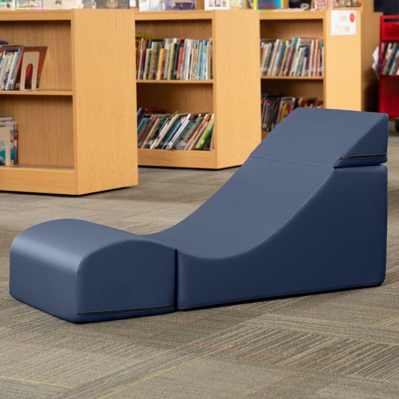 Jaxx Flexx convertible foam chair in navy blue vinyl staged in a school library reading corner