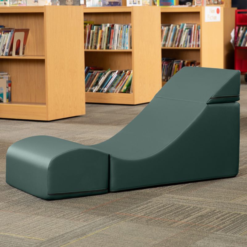Jaxx Flexx convertible foam chair in deep sequoia green vinyl staged in a school library reading corner