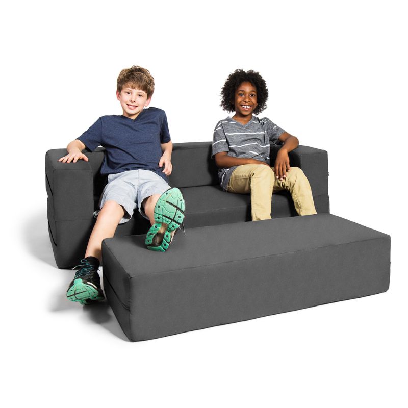 Two kids seated on the Jaxx Zipline flip sofa in grey, demonstrating the sofa and ottoman set at real scale for a classroom or playroom