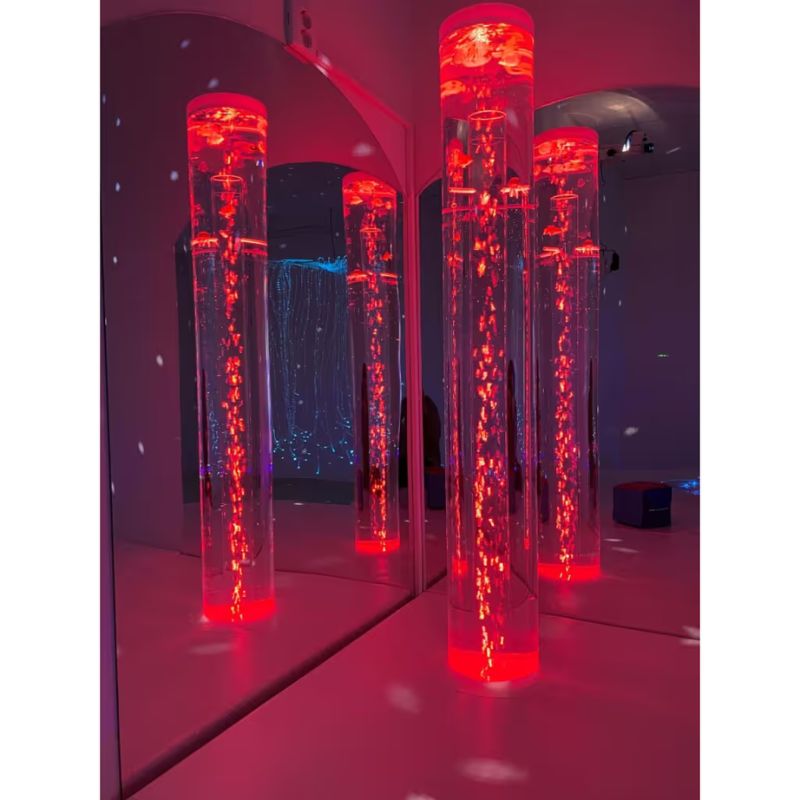 Bubble tubes reflected in mirrored acrylic sides beside the TFH Corner Bubble Tube Podium under red lighting