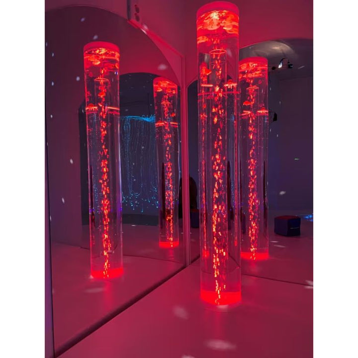 Bubble tubes reflected in mirrored acrylic sides beside the TFH Corner Bubble Tube Podium under red lighting