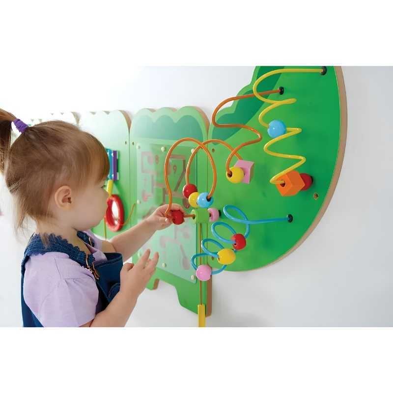 A young child threads beads along the tail section of the TFH Crocodile Activity Wall Panel, a wall mounted sensory busy board for fine motor play