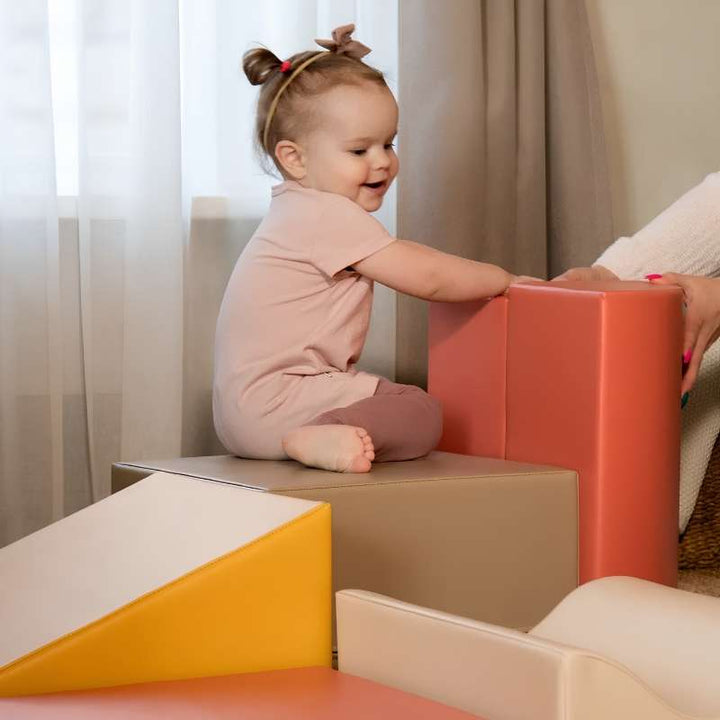Baby sitting beside the IGLU Discoverer Soft Play Set in Pastel Fries in a home living room setting