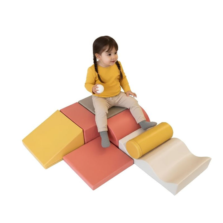 Toddler girl sitting on the IGLU Discoverer Soft Play Set in Pastel Fries, a foam activity set for climbing and balance