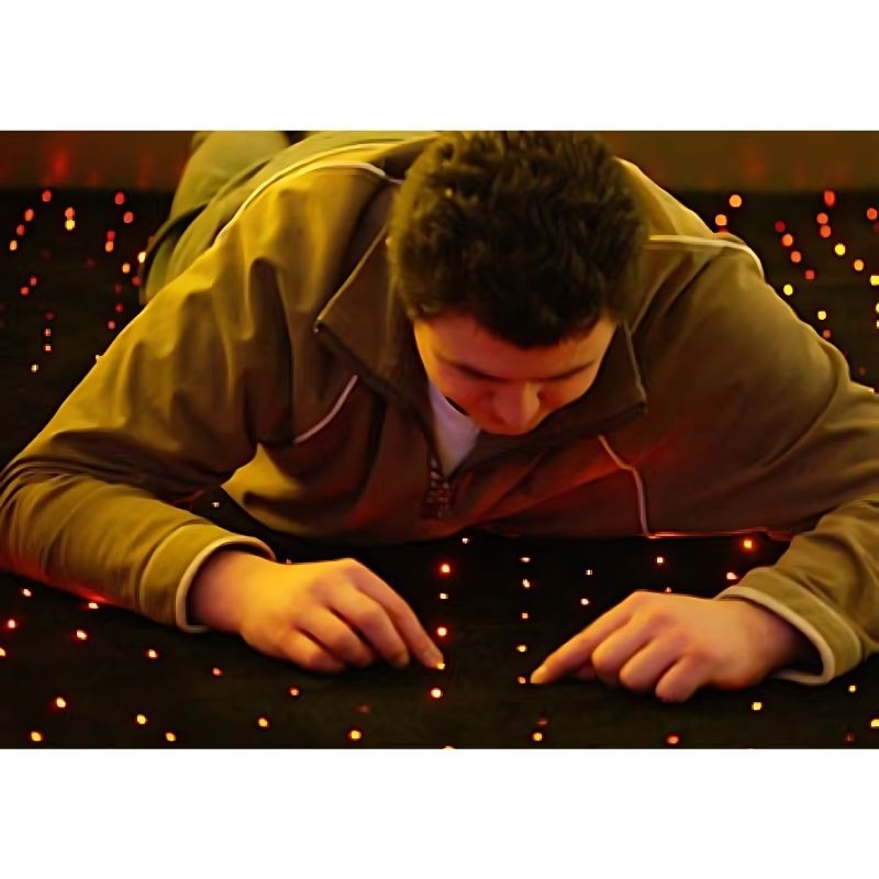 Adult engaging with the Experia Calming Sensory Room fibre optic lighting, demonstrating passive sensory relaxation and de-escalation in a therapy or care setting