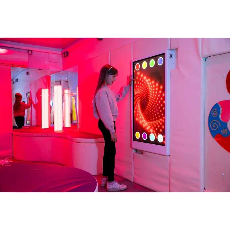 Teen engaging with the Experia Intelli Panel Infinity interactive sensory wall panel in a red-lit sensory room
