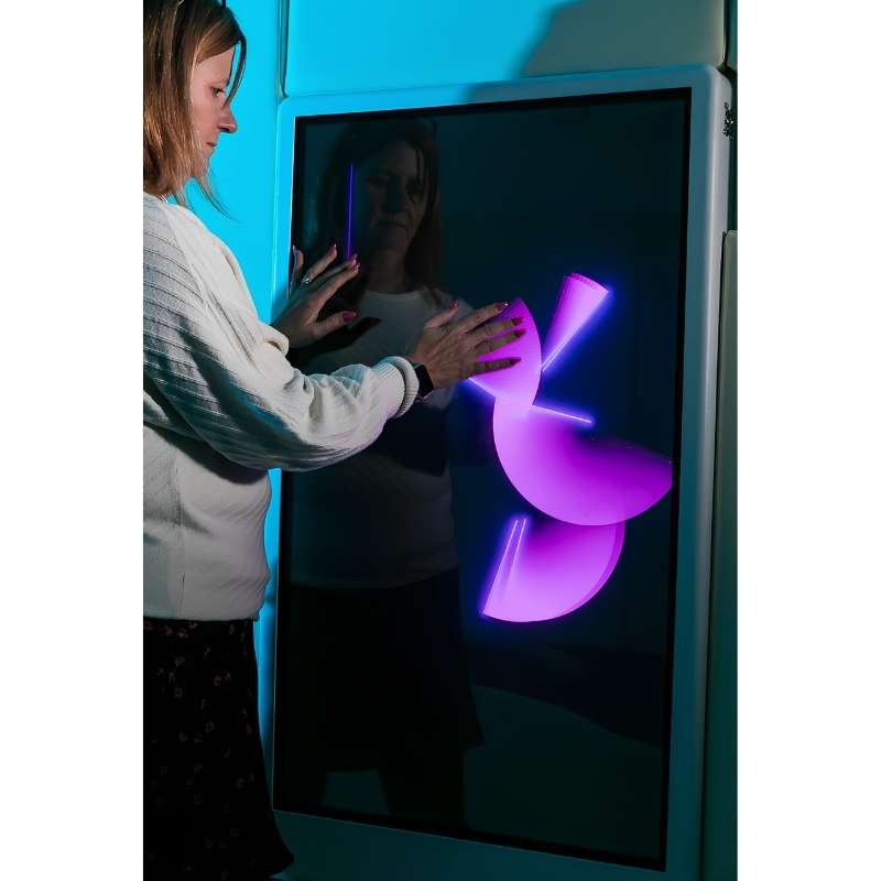 Adult engaging with the Experia Intelli Panel Musical Touch touchscreen sensory panel in pink light, second view