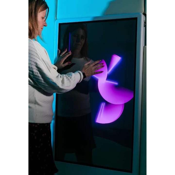 Adult engaging with the Experia Intelli Panel Musical Touch touchscreen sensory panel in pink light, second view