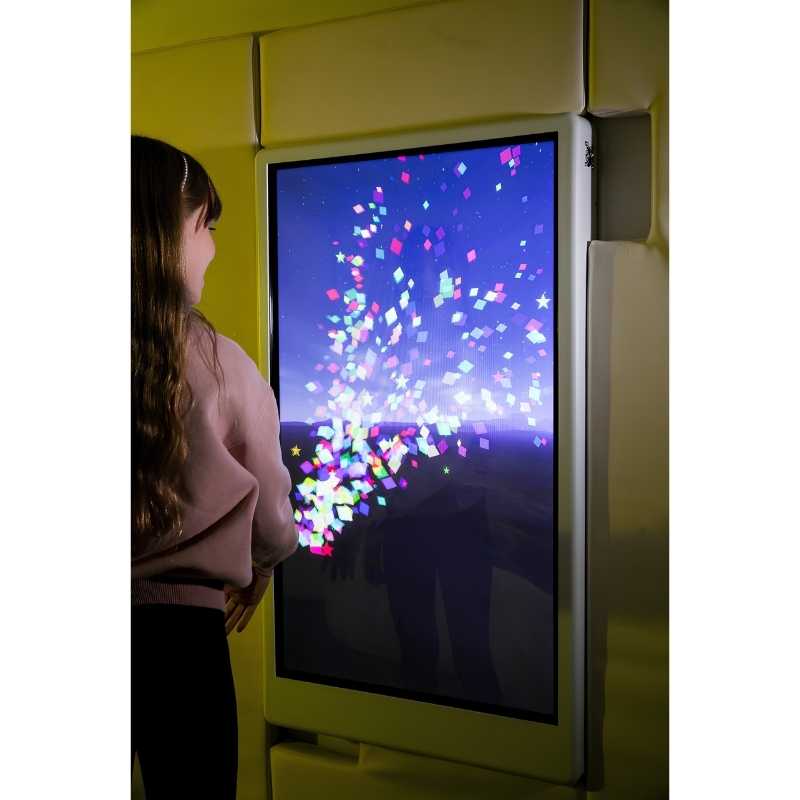 Close-up of a child engaging with the Experia Intelli Panel Particle interactive sensory wall panel in a yellow-lit room