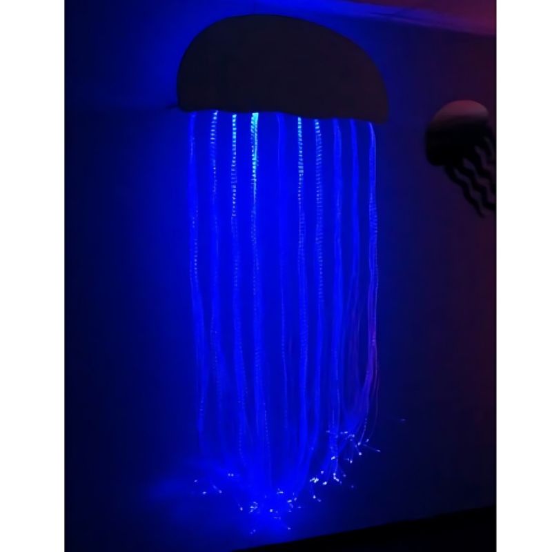 Experia IRiS Fibre Optic Jellyfish front view in blue light showing the 150 colour-changing fibre optic tentacles hanging from the wall-mounted enclosure