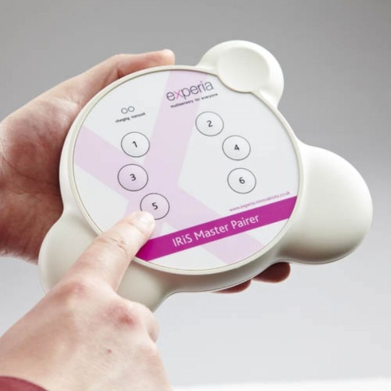 Experia IRiS Master Pairer 6-way wireless device held in hand, used to pair Talkers and Listeners across the interactive multi-sensory room package
