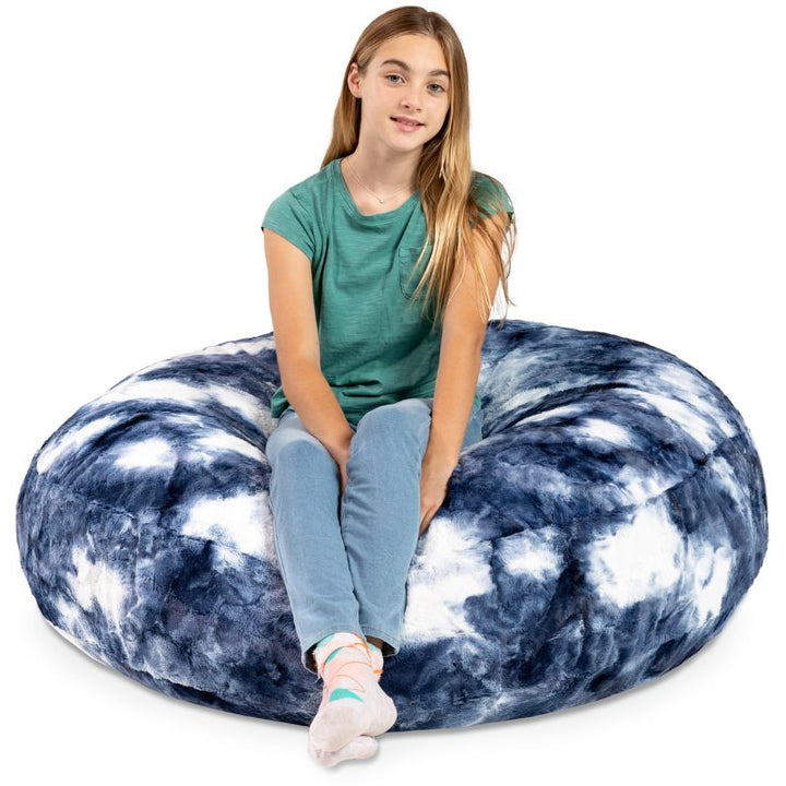 A child sitting on the Jaxx Cocoon Fur faux fur bean bag chair in Blueprint, a crash pad option for kids in classrooms