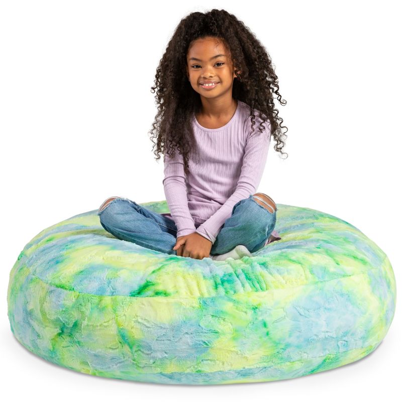 A child sitting on the Jaxx Cocoon Fur faux fur bean bag chair in Firefly, a tie-dye seat kids use every day