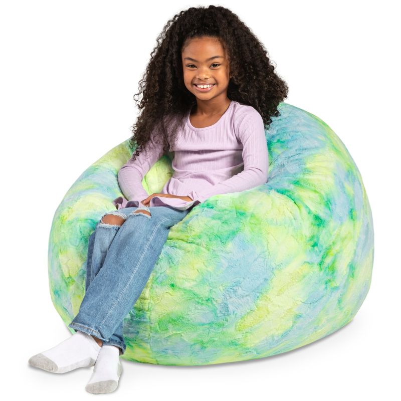 A child reclining into the Jaxx Cocoon Fur faux fur bean bag chair in Firefly, a tie-dye lounging seat for kids