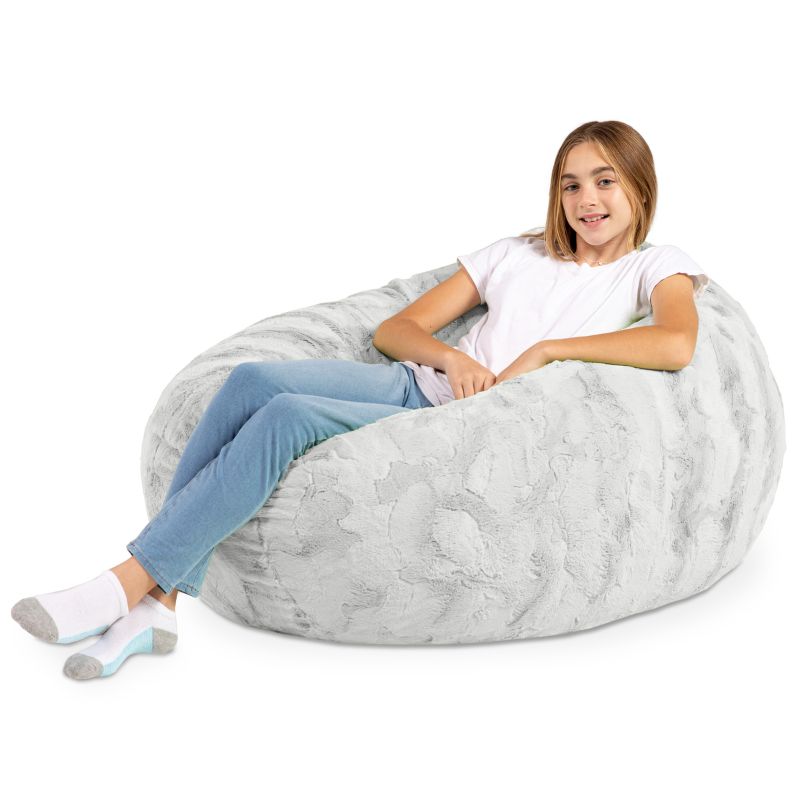 A child reclining into the Jaxx Cocoon Fur faux fur bean bag chair in Grey, a neutral lounging option for kids
