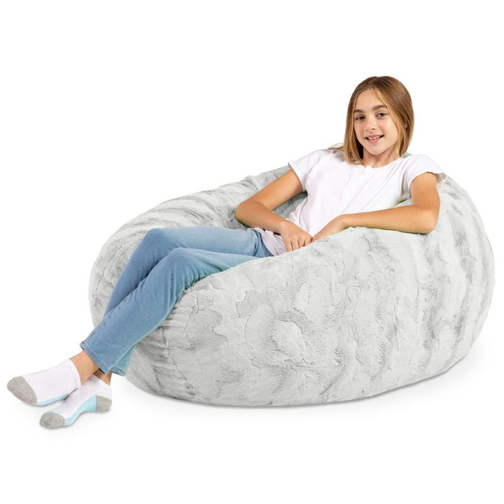 A child reclining into the Jaxx Cocoon Fur faux fur bean bag chair in Grey, a neutral lounging option for kids