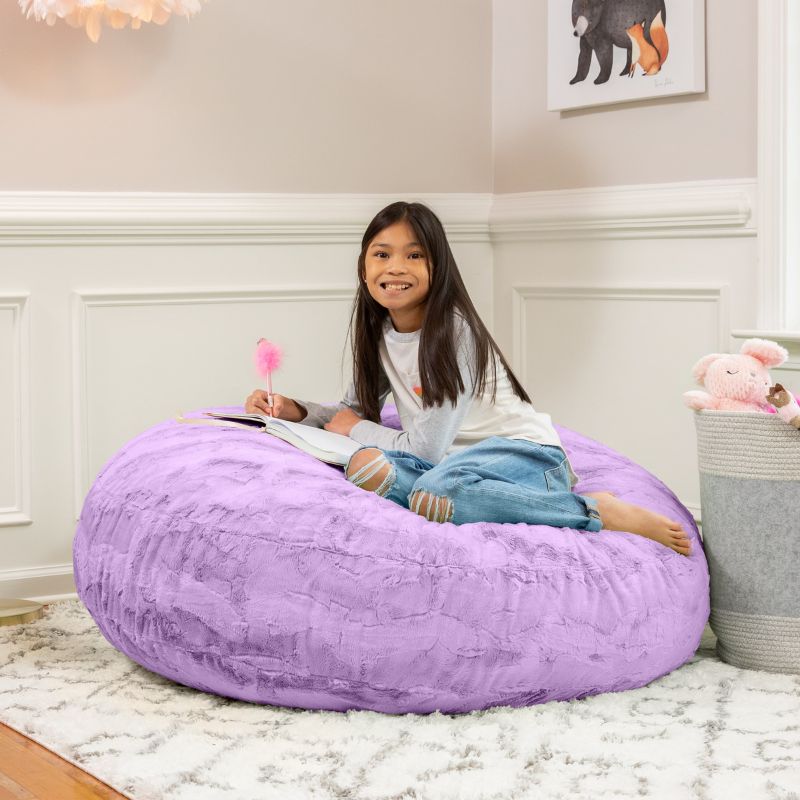 A child reading on the Jaxx Cocoon Fur faux fur bean bag chair in Purple, styled in a bedroom as everyday kids' seating