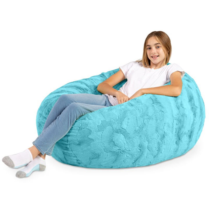 A child reclining into the Jaxx Cocoon Fur faux fur bean bag chair in Teal, a cozy sensory lounging position for kids