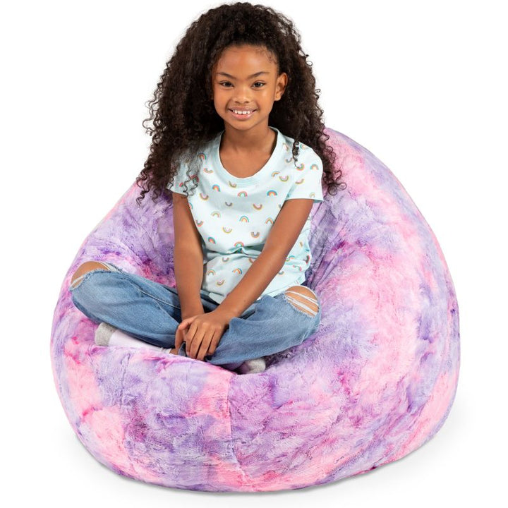 A child reclining into the Jaxx Cocoon Fur faux fur bean bag chair in Unicorn, molded into a supportive lounging shape