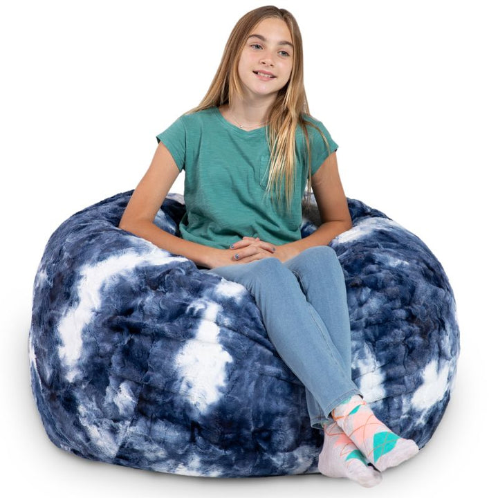 Teen seated in the Jaxx Saxx faux fur bean bag chair in Blueprint, a marbled tactile sensory seat for kids