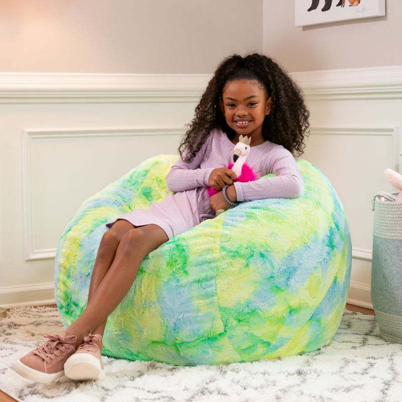 Girl sitting on the Jaxx Saxx faux fur bean bag chair in Firefly in a bedroom setting, a bright tactile sensory seat for kids