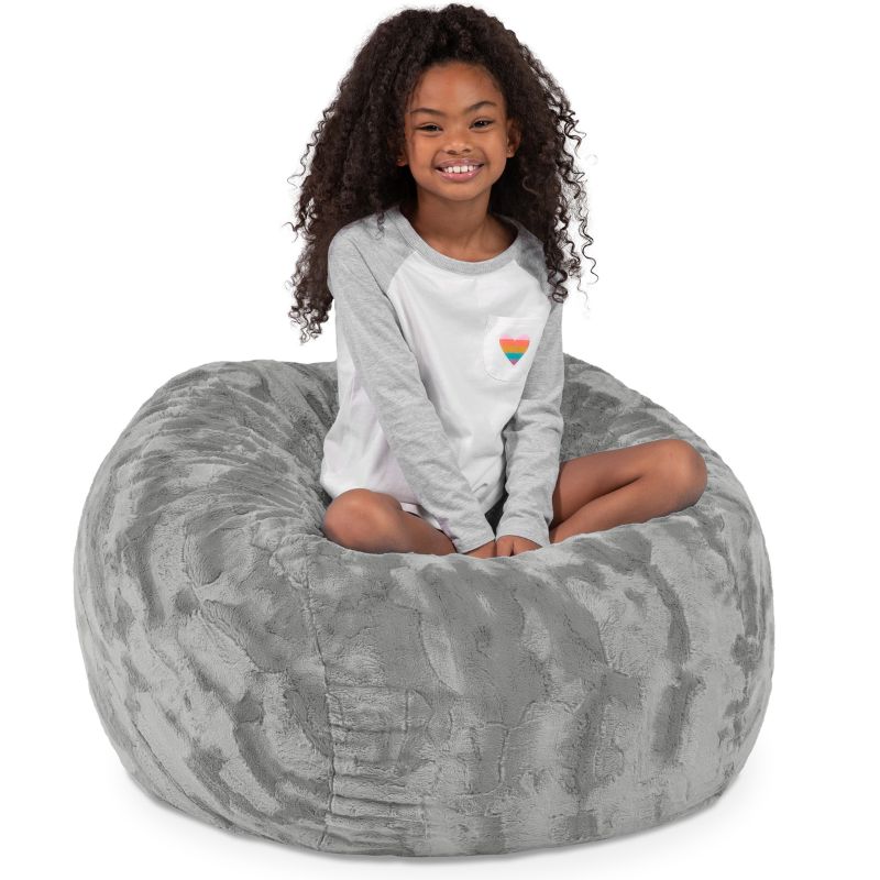 Child seated in the Jaxx Saxx faux fur bean bag chair in Grey, a cozy tactile sensory seat for kids