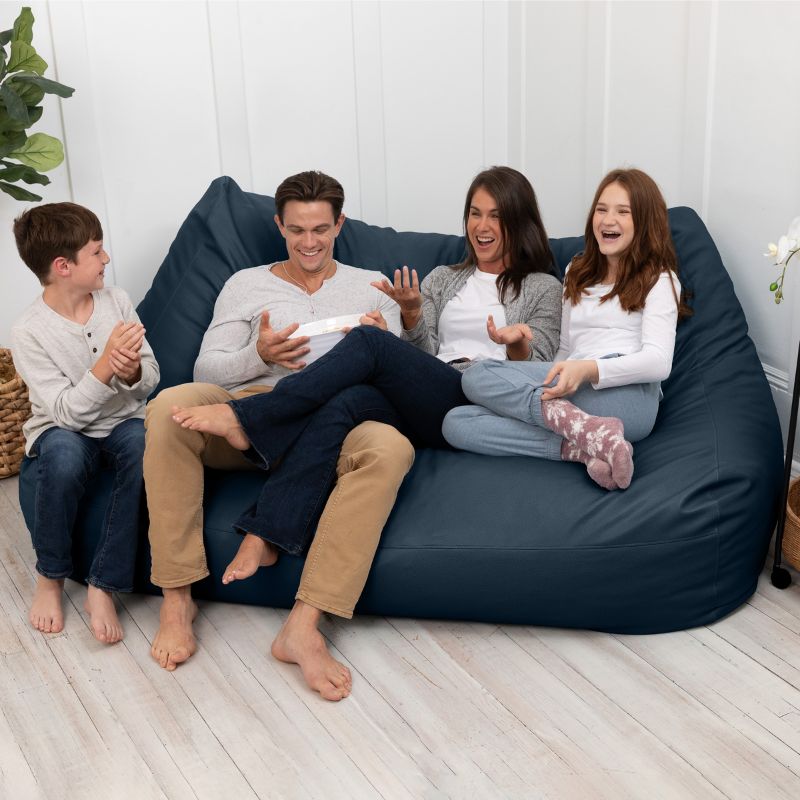 A family sharing the Jaxx Lozia faux leather loveseat in oxford blue, two-seat waiting room seating