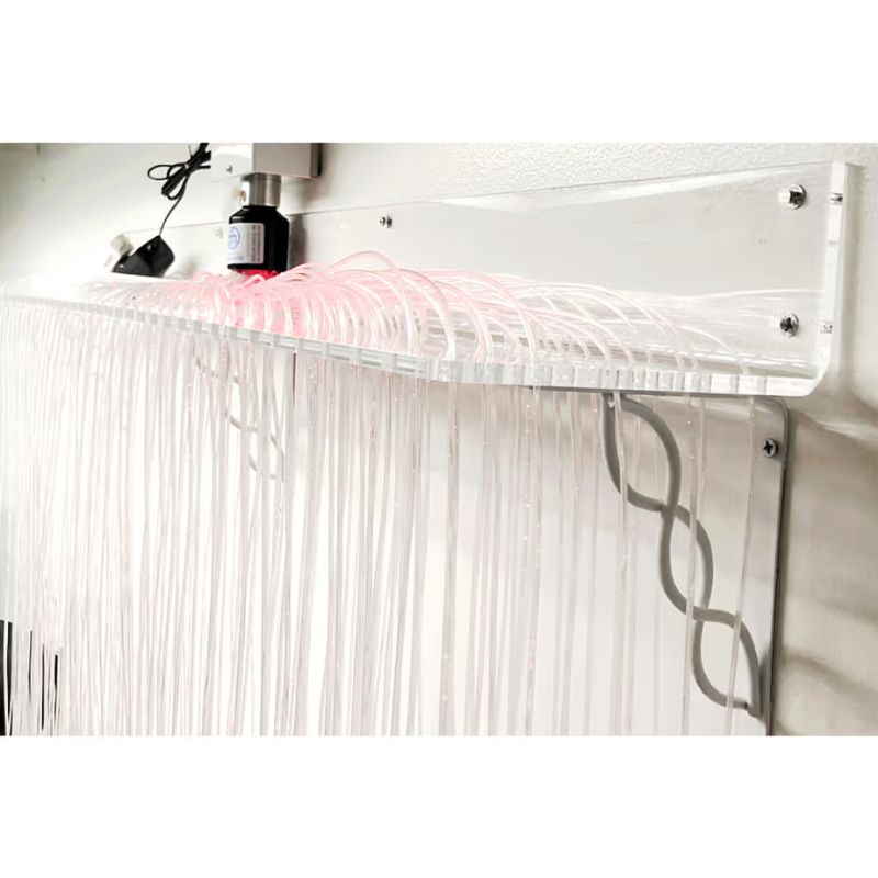 Close up of the TFH Fibre Optic Curtain Wall Mount's clear acrylic bracket holding 200 tails in soft pink light