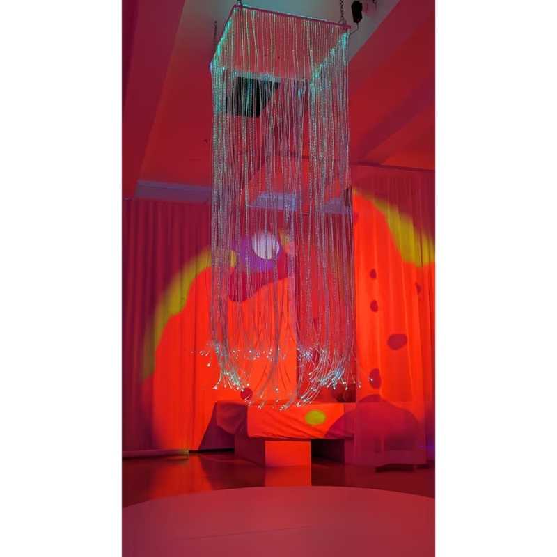 TFH Fibre Optic Curtain ceiling mounted in a colour lit sensory room, creating a calming visual display of glowing strands for therapy and play