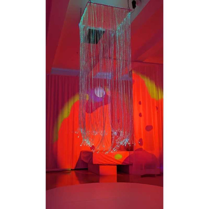 TFH Fibre Optic Curtain ceiling mounted in a colour lit sensory room, creating a calming visual display of glowing strands for therapy and play