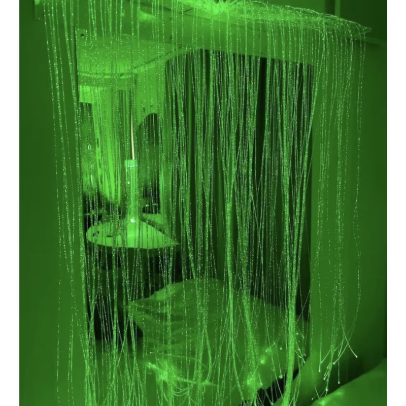 TFH Fibre Optic Curtain Wall Mount glowing green in a sensory room, showing the full colour changing curtain effect